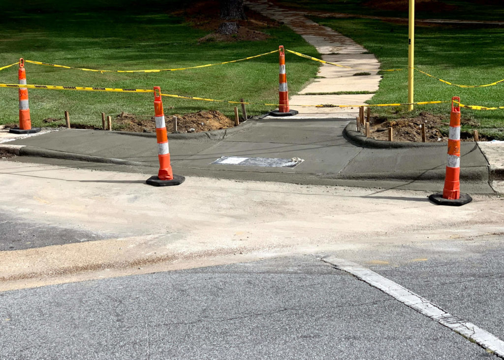 Newly placed concrete is blocked by pylons along a residential street in North Carolina.