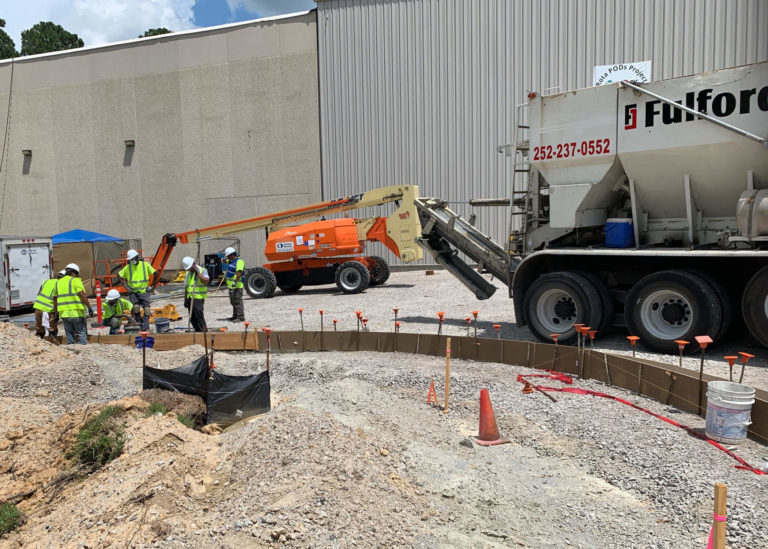 A volumetric concrete mixer backs up to place concrete at Merck in Wilson, NC.