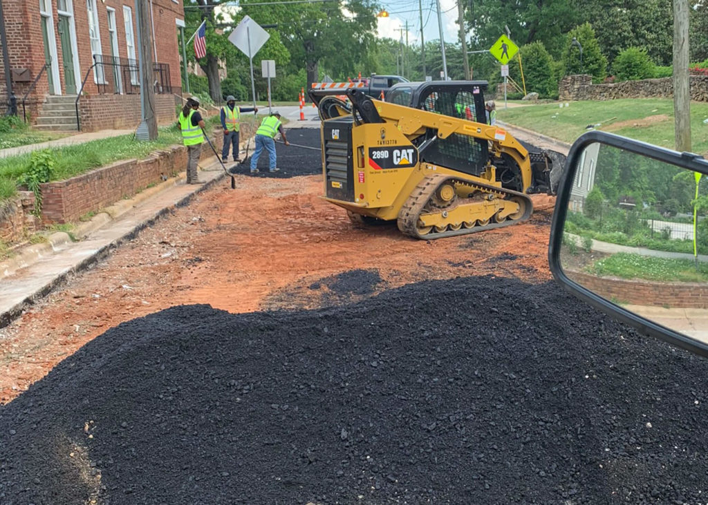 Crews spread asphalt over bare ground to replace a roadway in North Carolina.