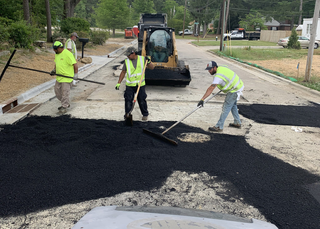 Worker spread hot asphalt during a street repair in North Carolina.