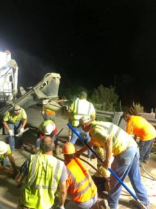 Concrete workers use tools to place concrete in a bridge joint at night along I-95 in Roanoke Rapids, NC.