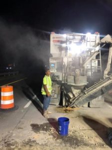 A volumetric concrete mixer operator watches from the control panel during nighttime bridge joint work along I-95 in Roanoke Rapids, NC.