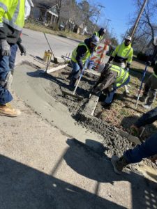 Workers place freshly poured concrete around a new curb in Wilson County, NC.