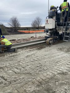 Workers from Fulford & Jones, Inc., use a curb machine for a project at the Kinston, NC, airport.
