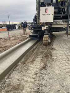 A curb machine forms a new concrete curb at the Kinston, NC, airport.